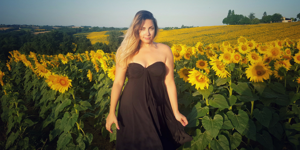 Woman wearing black strapless chic summer dress in a field of sunflowers | Diane Kroe 