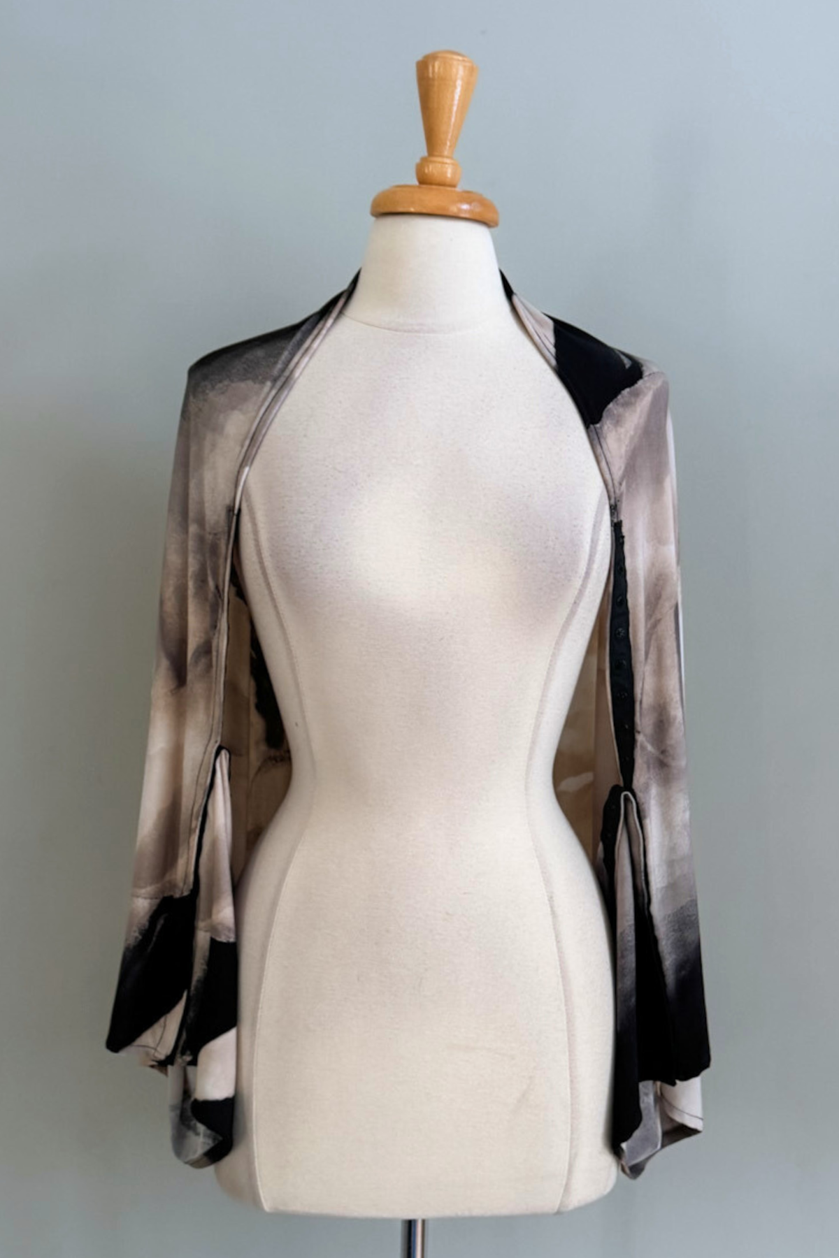 Oasis Sand print Carry-on Cozy worn as a long cardigan on a mannequin against a plain background