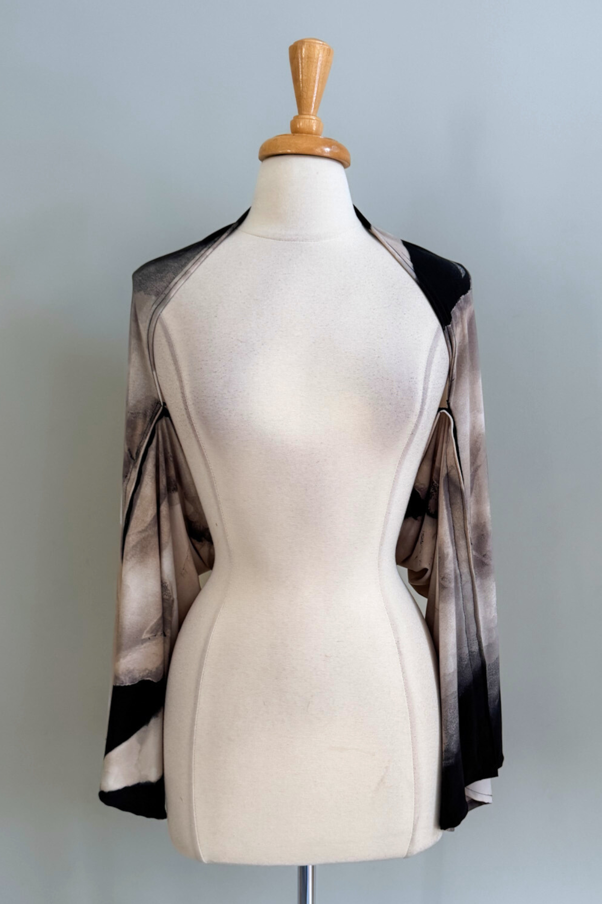 Oasis Sand print Carry-on Cozy worn as a cardigan on a mannequin against a plain background